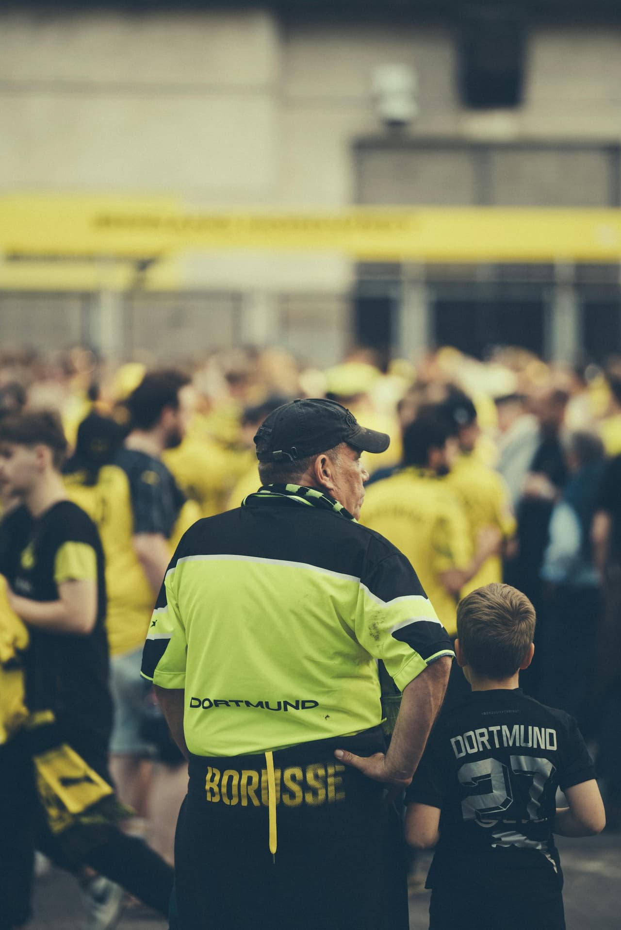 Grandfather and grandson walking to a football match together